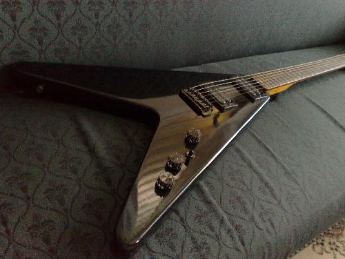 V Guitar - shot taken while guitar lies on the couch. Color: black
