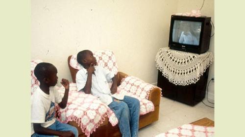 Two kids watching tv - Two kids watching a tv in their room.