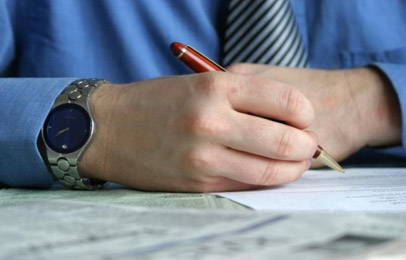 Writing - A man in a blue shirt writing.