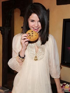 selena having a cookie - selena poses eating a cookie,wow I would love to have a bite of it :)