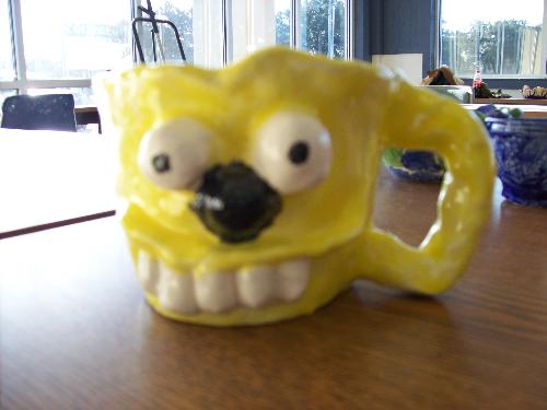 A Face Mug - This is a face mug that I was told to make. It more like a redneck person since you dont see all his teeth but then other have commented that it look like character from The Simpsons show.. 

