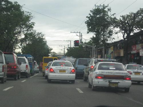 taxi cabs - taxi cabs with other vehicles as they wait for the traffic light to change