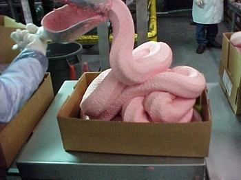 ice cream factory - Pink ice cream in soft-form coming out of a machine for bulk packaging