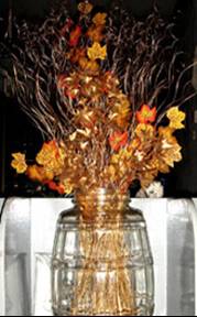 Autumn in a pot - oranges and gold flowers and stems in a crystal vase