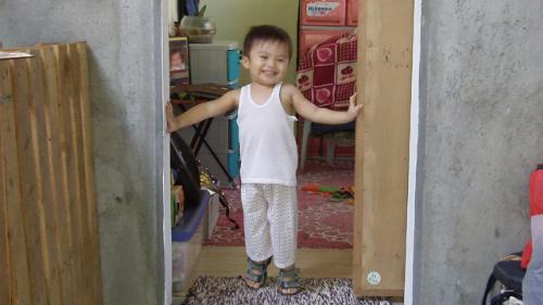 Geeboy at home - Our son Geeboy standing in front of his room.