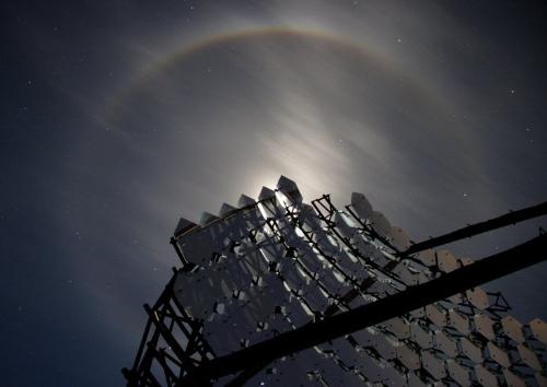 night sky - As a bright November Moon lit up the night sky last week, Gil Esquerdo spotted this lovely Moon halo overhead at the Whipple Observatory on Mt. Hopkins, Arizona. In the foreground, the structure and individual component mirrors of Whipple's 10 meter gamma-ray telescope actually block direct light from the lunar disk, emphasizing the halo in this dramatic view. The halo was caused by ice crystals in the thin high clouds above the observatory - crystals that are hexagonal in shape and produce the characteristic ring of light with a 22 degree radius. In fact, the ice crystal shapes are much like the flat, hexagonal mirrors of the specialized telescope in the picture. Used together the mirrors can collect brief flashes of optical light caused by high-energy gamma-rays impacting Earth's atmosphere.