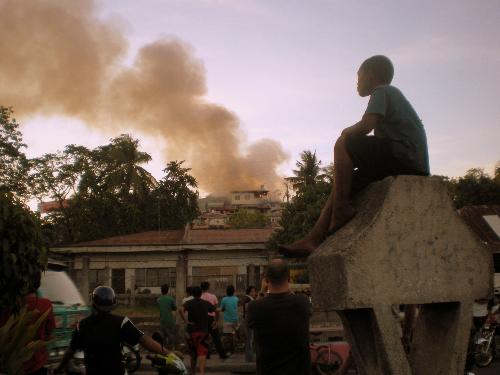 House on Fire! - A photo of a house on fire with a crowd of onlookers observing the disaster.