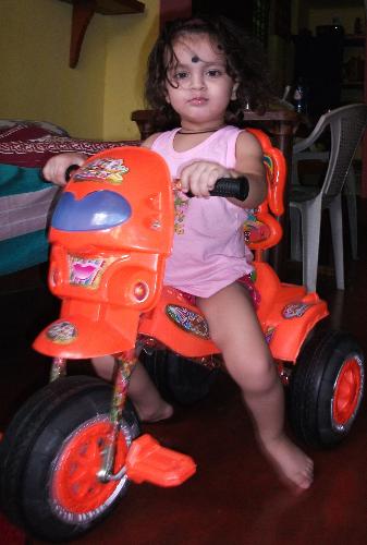 on her tricycle - my grand daughter on her tricycle