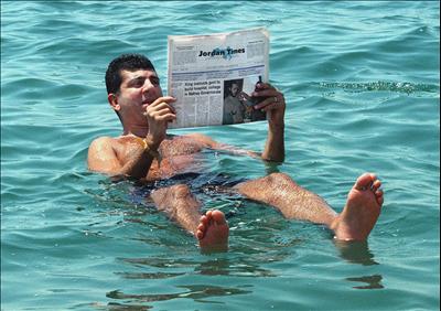 The dead sea - A floating man reading his newspaper inside the Dead Sea waters.