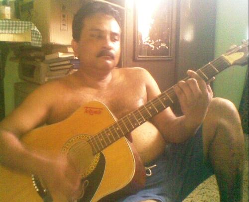 me playing a guitar - This is a photo of me in mu house playing or trying to play a jumbo acoustic guitar.
