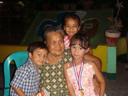 My Grandmother - This is my loving Grandmother. she's the best story teller. i love her. at the picture, she's with my cousins. mico, lei, and angelica. this picture was taken at angelica and mico's preparatory graduation, where angelica got the highest achievement in their class.