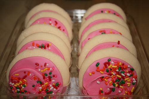 pink frost - A carton of grocery store sugar cookies with thick pink frosting