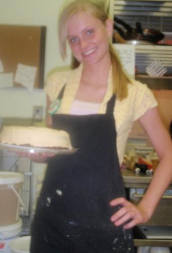 At work! - Me at work holding a Reese&#039;s cake! I had just put the peanut butter whipped topping on it, and was getting ready to decorate it! Yummy!