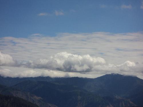 clouds - A photo of clouds above the green mountain.