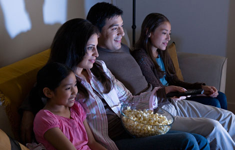 Watching A Movie - A family of four watching a movie.