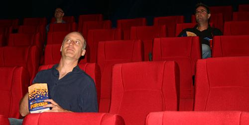 Movie Theater 3 - Three men sitting alone in a movie theater.