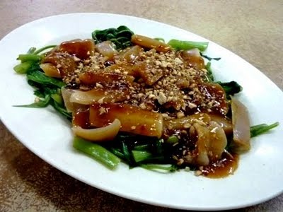 Rojak Sotong Kangkung - An image of rojak sotong kangkung. It was made from kangkung (water spinach) and big squid. Boiled and then the gravy or rojak paste are put on the top of them.