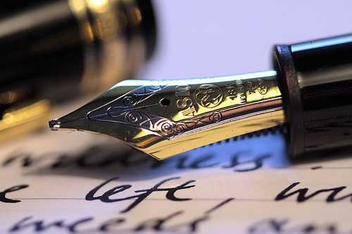Fountain Pen Writing - A tradition fountain pen above a page of sample writing. The old-fashioned way of putting ideas to paper.