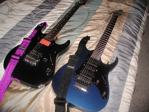 guitars - Two guitars lying on a bed.