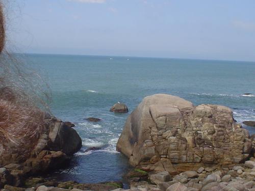 A view near Bombinhas beach, Santa Catarina - The Atlantic Ocean is showing its majesty as well as the huge boulders.