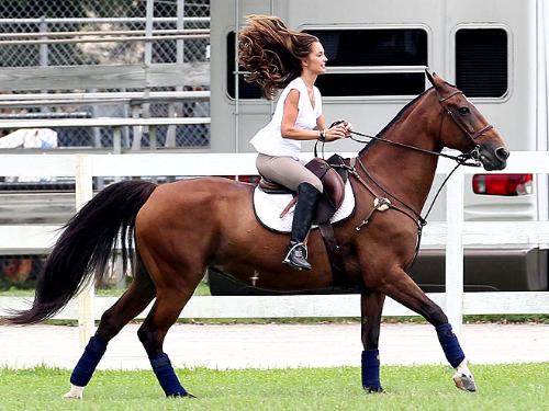 Minka Kelly - Her riding looks awlful! She is to far back in the saddle. Her legs need to be straight and heels down! Looks like she has the reins in one hand pulling on horses mouth! The horse doesn't very happy!