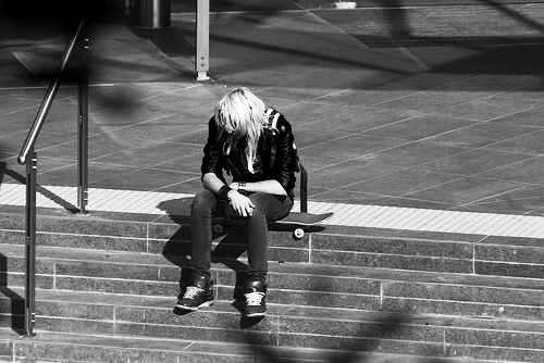 girl - a lonely girl sitting on a sidestreet.