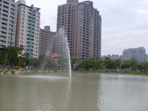 A lake in the middle of the city. - There is this lake near my home , we go very often to walk around and seat on its shore, its a beautiful sceen to see the lake infront of the buildings. Also the lake has many turtles and fish that we enjoy. I love to see when that fountain comes on and can feel the breeze of the water when the air blows . Kaohsiung has many lakes, but , this one is one of my favorite.