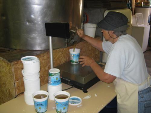 pure golden Honey - pouring honey from the holding tank