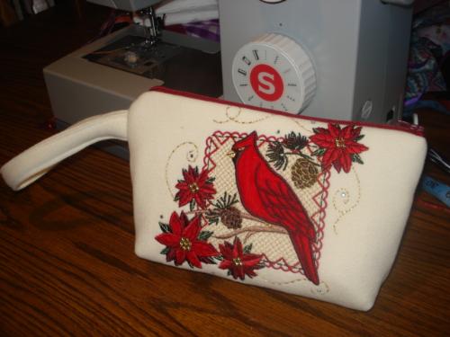 Embroidered red robbin with poinsettia flower wris - Embroidered red robbin with poinsettia flower wristlet. size is 9X7 inches with a 6 inches handle. materials are cotton. Just I love the design. it's 25 dollar free shipping the US