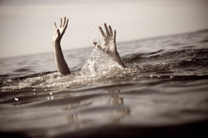 woman drowning - a drowning woman raises arms for help