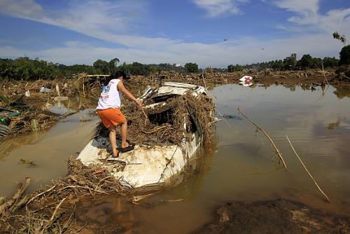 Typhoon Sendong - A woman inspects a submerged vehicle in a village hit by flashfloods brought by Typhoon Sendong in Cagayan de Oro, Northern Philippines.

More than 500 people were killed, most in their sleep, as tropical storm Sendong swelled rivers and triggered flash floods, which devastated the cities of Cagayan de Oro and Iligan. Unaccustomed to serious storms, the floods turning two coastal cities into muddy waterways strewn with overturned vehicles and toppled trees.