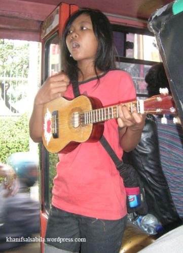 busker on the bus - A busker is playing the guitar, singing on the bus in the hope of getting money from passengers.   photo by hanifsalsabila.wordpress.com