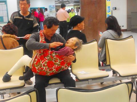 A man carries his mother, wrapped in a blanket - A man carries his mother, wrapped in a blanket because she was too frail to sit in a wheelchair, to a hospital in Greater Tainan on Friday.