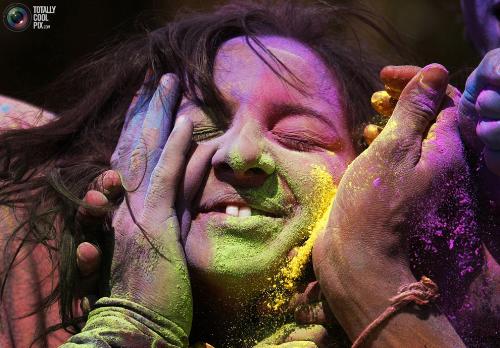 We also play the holi like this - Women applying colour powder on my face example