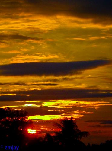 Summer  - A golden specks scattered on the sky as the sun slowly hiding its fiery smile behind the dark clouds.