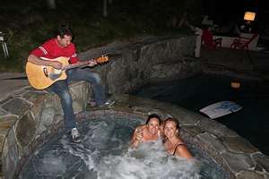 Serenading - A man serenading the two ladies while they are enjoying their swimming. Serenading - A man serenading the two ladies while they are enjoying their swimming.