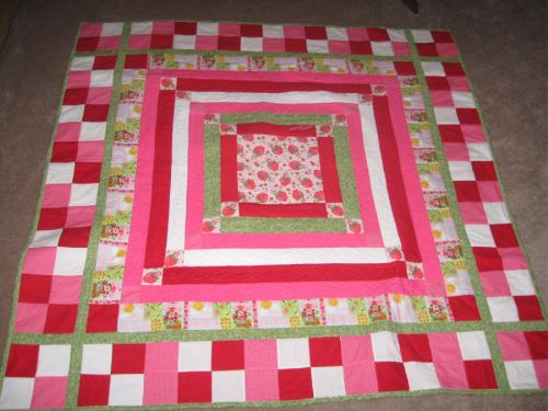 Strawberry Shortcake - nearly queen size quilt - I finished this one...bigger than I expected, but since I have trouble following patterns, I create and design them as I go! I wanted more of the character, but she is hard to find in the fabric store. So I just did strips and sashing and the back is all pink. Also did some stippling and meandering instead of STID.