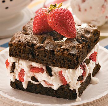 Ice Cream Brownie Sandwich - Ice cream sandwiches can be made by stuffing ice cream in between foods such as biscuits, cookies, crackers, brownies, pieces of cakes or even bread. This sandwich is made up with vanilla ice cream with strawberries and chocolate chips and stuffed between nutty brownies. Yummy.