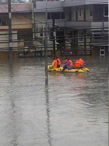 Rescuers on the flooded road - Rescuers braved the flood to rescue the stranded people on top of their roofs.
