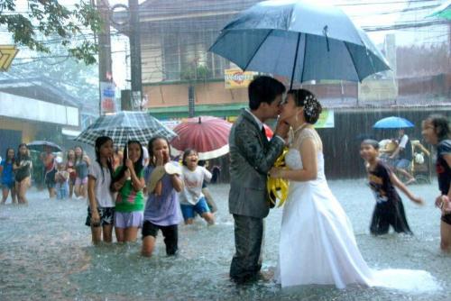 Couple kissing in the midst of flood. - See this cute couple who are wed in the middle of a flood.