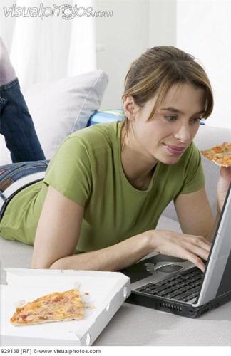 A women doing the work in Computer while eating - Working on Computer while eating