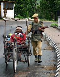 humanity  - a police man helping a physically retarded person at assam