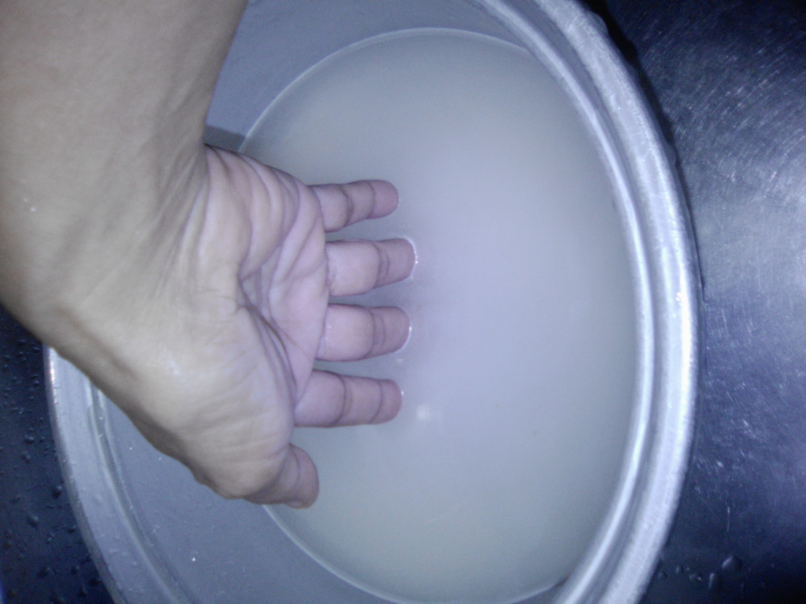 that is my hand measuring the water in the rice cooking vessel that is my hand measuring the water in the rice cooking vessel