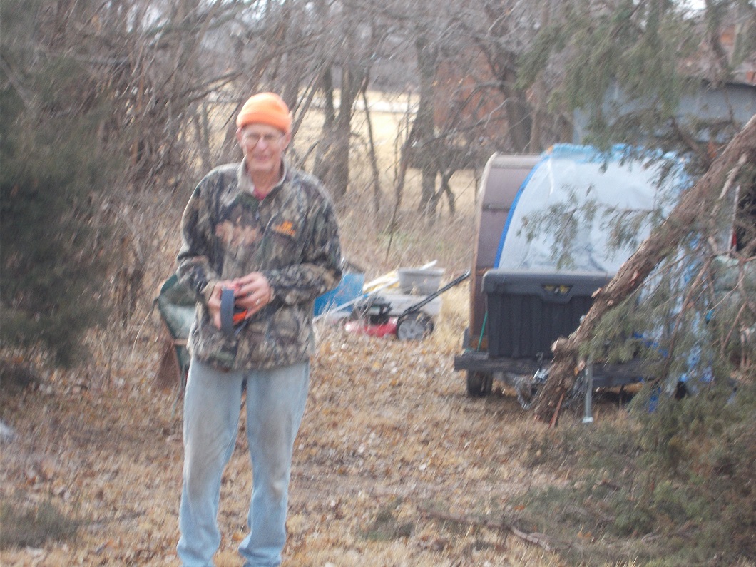 Hubby in front of our cedar branch. He is holding ear covers to protect his hearing Hubby in front of our cedar branch. He is holding ear covers to protect his hearing