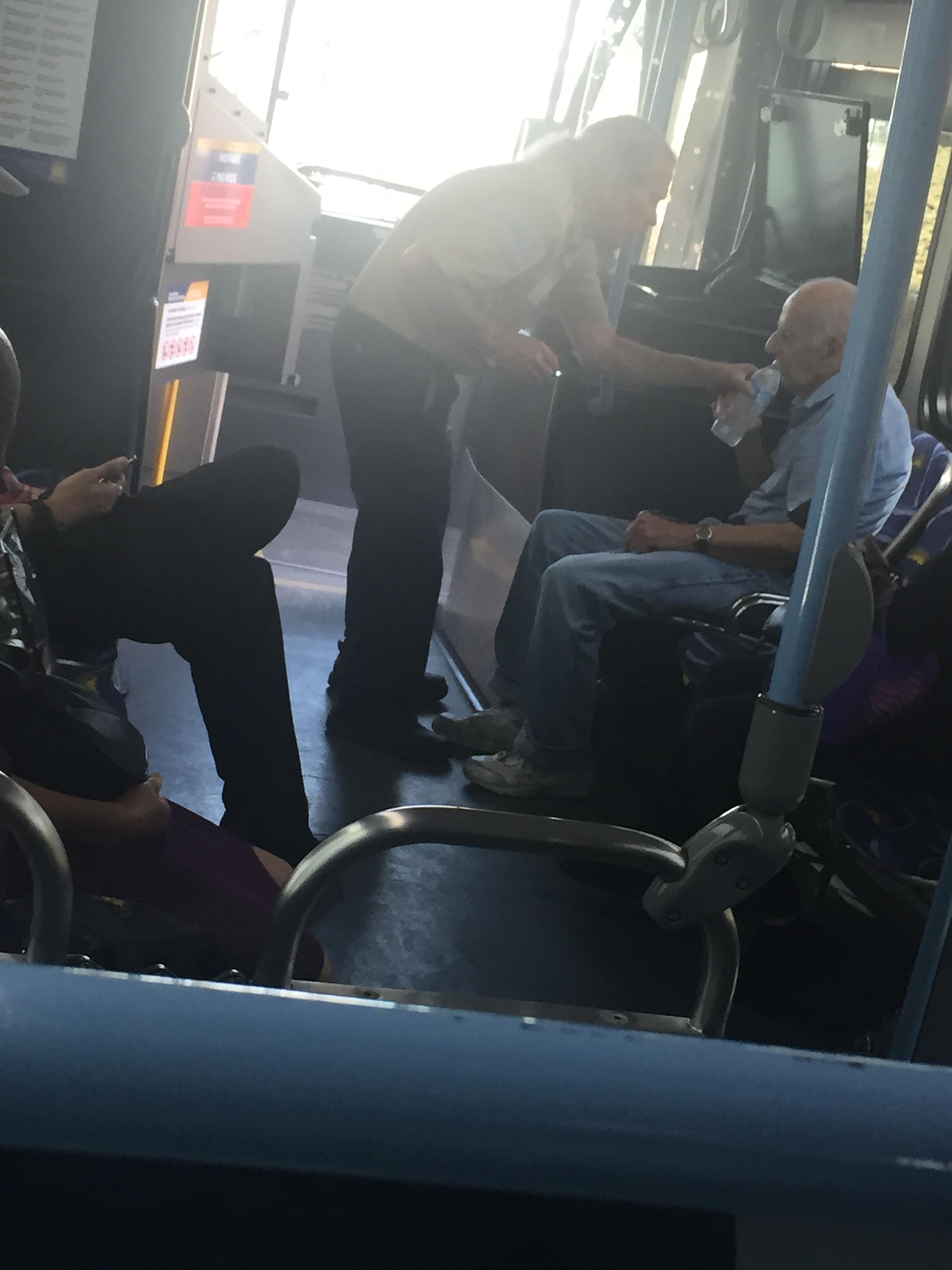 Mike Blair giving a bottle of water to a passenger in Las Vegas aboard a bus Mike Blair giving a bottle of water to a passenger in Las Vegas aboard a bus