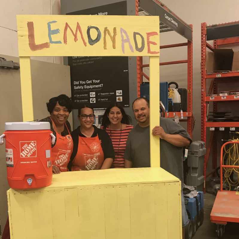 The employees of the Home Depot and Dawn Redmon with a lemonade stand The employees of the Home Depot and Dawn Redmon with a lemonade stand