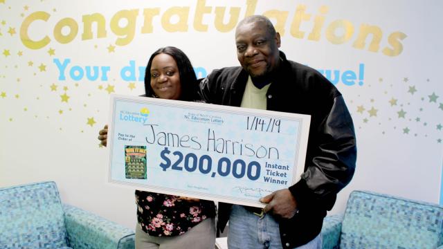 James Harrison and his daughter with the $200,000 check from the lottery