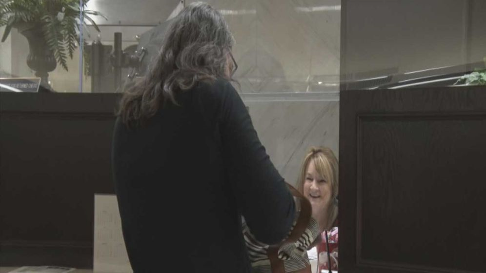 A clerk at the Yukon City Hall receives a payment for the water bill A clerk at the Yukon City Hall receives a payment for the water bill