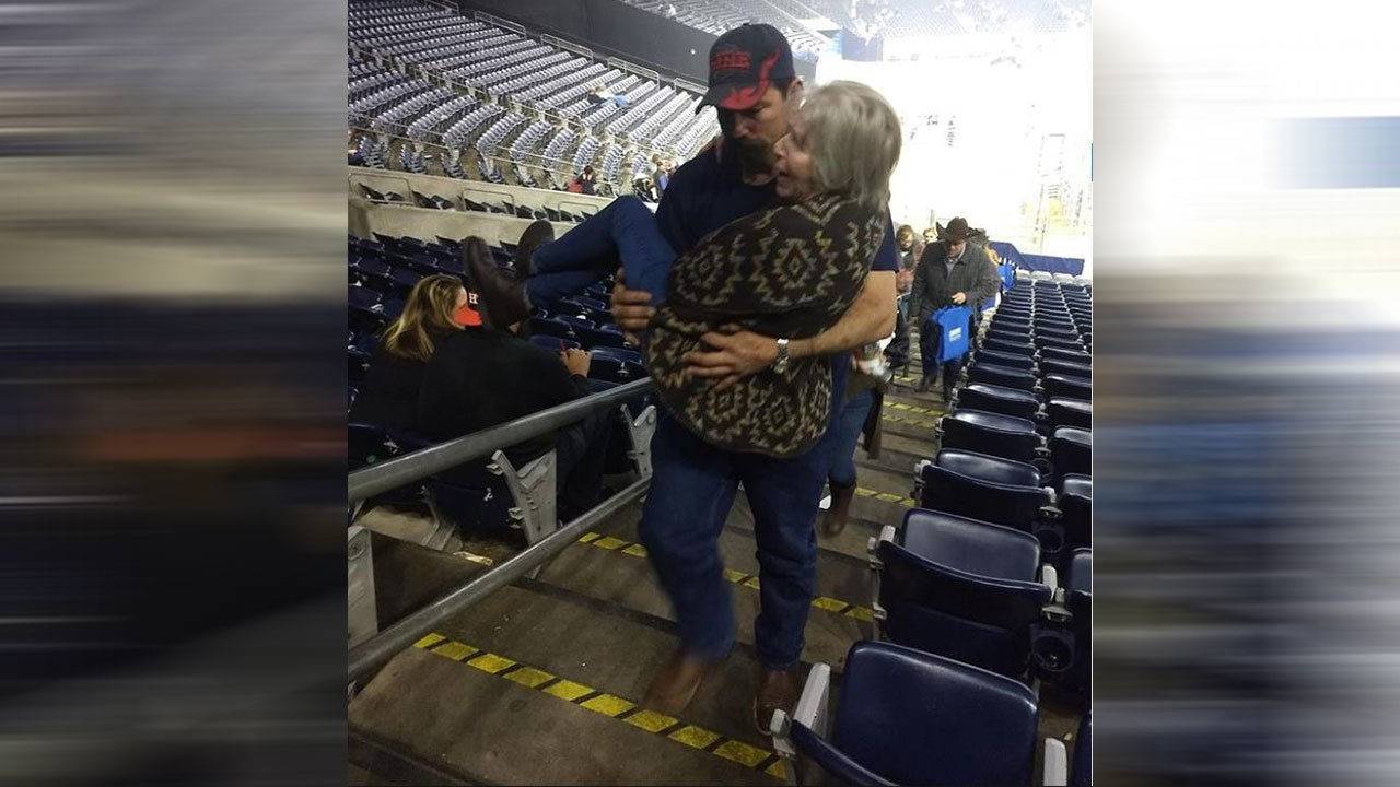 Matthew Harwell carrying a senior citizen climb stairs at a rodeo in Texas 