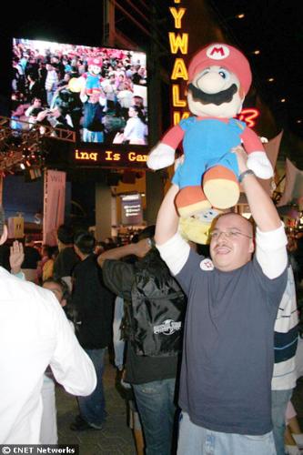 Doll - A man with a giant Mario doll dances in front of the stage set up near the EB Games store, where Nintendo launched the Wii in Los Angeles.